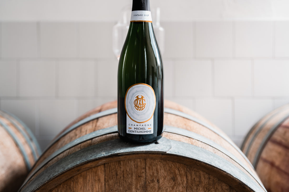 Bouteille Vintage 2007 posée sur un fût, collerette dorée