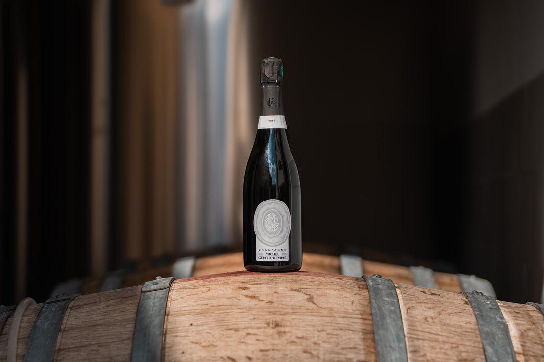 Bouteille de Rosé posée sur un fût, dans la cave