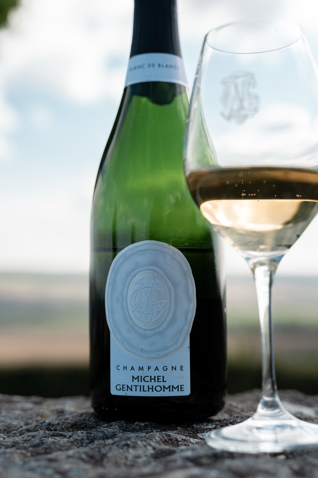 Blanc de Blancs et coupe servie, posés sur un muret de pierre